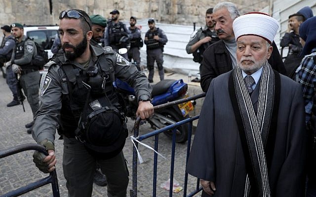 El 12 de marzo de 2019, un oficial de la policía fronteriza le impide a Grand Mufti Muhammad Ahmad Hussein (R) ingresar al recinto del Monte del Templo en la Ciudad Vieja de Jerusalén, después de que se cerró cuando se lanzó una bomba incendiaria contra los agentes de policía. (Ahmad Gharabli / AFP)