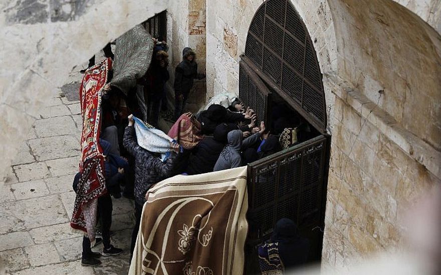 Los palestinos rompen una puerta de la Puerta de la Misericordia en el Monte del Templo en la Ciudad Vieja de Jerusalén el 15 de marzo de 2019. (Ahmad Gharabli / AFP)