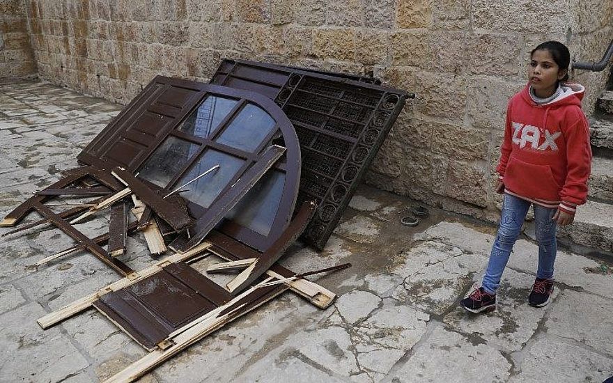 Una niña pasa junto a una puerta que los palestinos musulmanes rompieron en la Puerta de la Misericordia en el Monte del Templo en la Ciudad Vieja de Jerusalén el 15 de marzo de 2019. (Ahmad Gharabli / AFP)