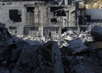 Una fotografía tomada el 26 de marzo de 2019, muestra a un hombre palestino abriéndose camino entre los escombros de un edificio en la ciudad de Gaza, después de que los ataques aéreos israelíes impactaron en decenas de sitios en la Franja durante la noche en respuesta al lanzamiento de cohetes desde el enclave palestino. (Mahmud Hams / AFP)