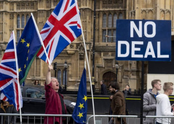 Activistas anti-Brexit exhiben las banderas de la Unión y de la UE mientras se manifiestan frente a las Casas del Parlamento en Westminster, Londres, el 28 de marzo de 2019. (Niklas Halle'n / AFP)