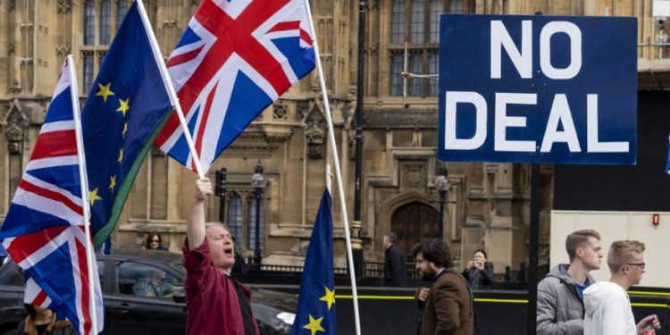 Activistas anti-Brexit exhiben las banderas de la Unión y de la UE mientras se manifiestan frente a las Casas del Parlamento en Westminster, Londres, el 28 de marzo de 2019. (Niklas Halle'n / AFP)