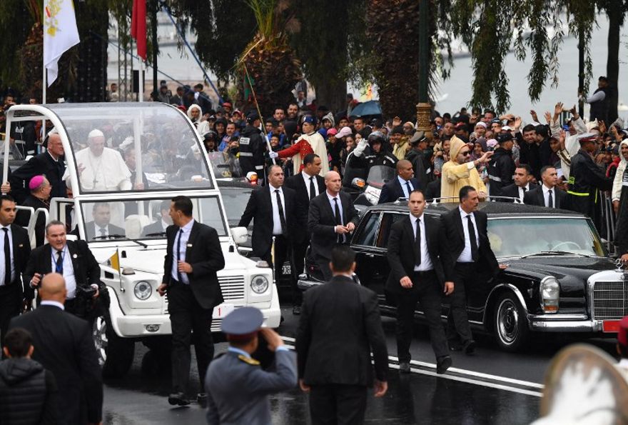 El rey Mohammed VI (R) saluda a la multitud desde su automóvil cuando llega con el Papa Francisco (L) en su papa móvil en la Plaza de Touran Hassan, a la llegada del pontífice al país norteafricano el 30 de marzo de 2019. (Alberto Pizzoli / AFP )