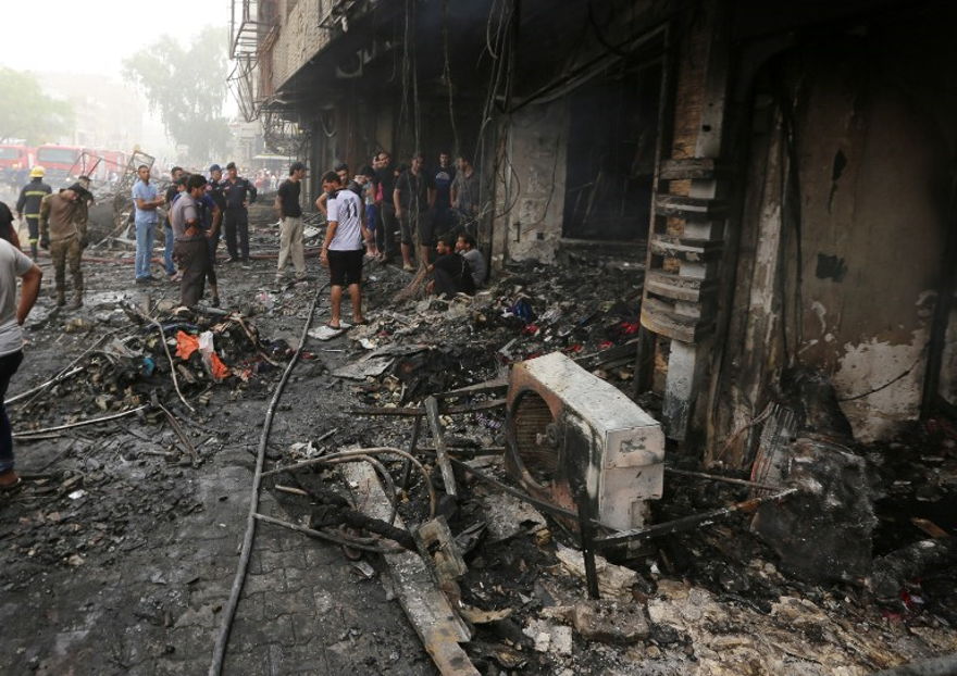 Los iraquíes inspeccionan los daños en el lugar de un atentado suicida con coche bomba reclamado por el Estado Islámico el 3 de julio de 2016 en el distrito central de Karrada en Bagdad. (Sabah Arar / AFP)