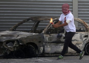 Un terrorista palestino se prepara para lanzar una bomba incendiaria durante los ataques a las fuerzas de seguridad israelíes en el campamento de refugiados de Shuafat en Jerusalem, el 9 de octubre de 2015. (Ahmad Gharabli / AFP)