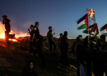 Los terroristas palestinos participan en una manifestación nocturna cerca de la cerca a lo largo de la frontera con Israel el 19 de marzo de 2019. AFP