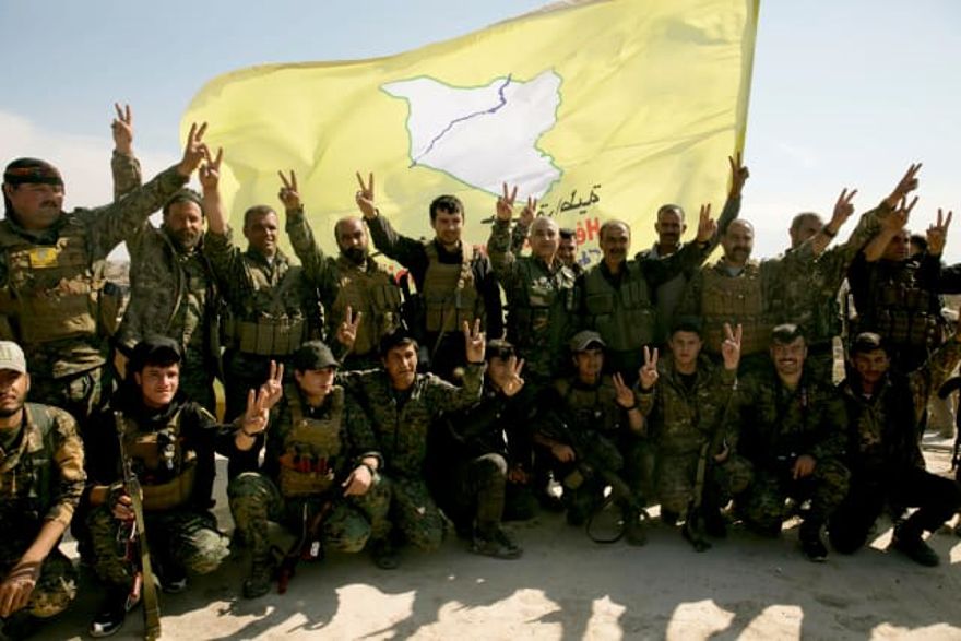 Los combatientes de las Fuerzas Democráticas Sirias respaldados por Estados Unidos posan para una foto en un tejado después de declarar el área libre de militantes del Estado Islámico, Baghouz, Siria, 23 de marzo de 2019. Crédito: Maya Alleruzzo, AP