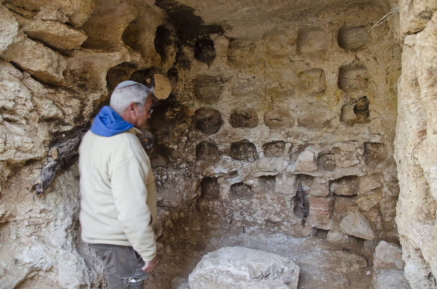 El arqueólogo Ya'akov Billig se encuentra cerca de un palomar ubicado en el sitio de entierro de la era Hasmonea que se está excavando en el barrio de Sharafat en Jerusalén. (Yoli Schwartz / Autoridad de Antigüedades de Israel)