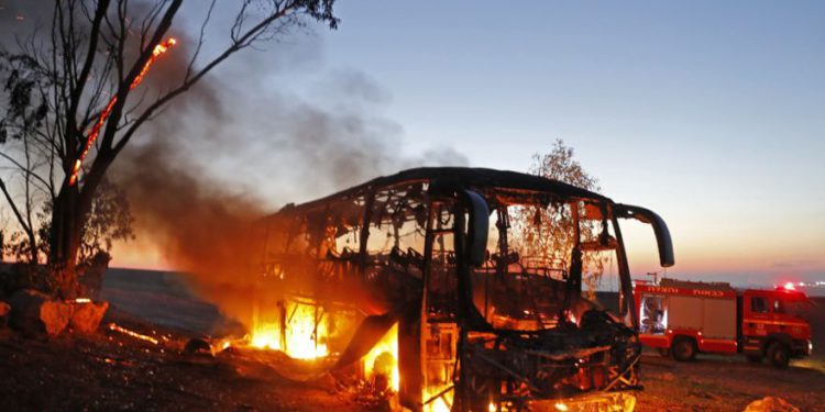 Una fotografía tomada el 12 de noviembre de 2018 muestra un autobús incendiado luego de ser alcanzado por un cohete lanzado desde la Franja de Gaza. (Crédito de la foto: MENAHEM KAHANA / AFP)