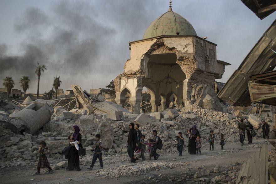 Los civiles iraquíes que huyen pasan por la mezquita al-Nuri destruida mientras las fuerzas iraquíes continúan su avance contra los militantes del Estado Islámico en la Ciudad Vieja de Mosul, Irak, el martes 4 de julio de 2017. (Foto AP / Felipe Dana)