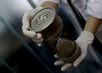 Ilustrativo: un miembro de la policía federal sostiene un reloj de arena con marcas nazis en la sede de Interpol en Buenos Aires, Argentina, 16 de junio de 2017. (AP / Natacha Pisarenko)