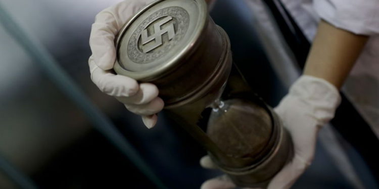 Ilustrativo: un miembro de la policía federal sostiene un reloj de arena con marcas nazis en la sede de Interpol en Buenos Aires, Argentina, 16 de junio de 2017. (AP / Natacha Pisarenko)