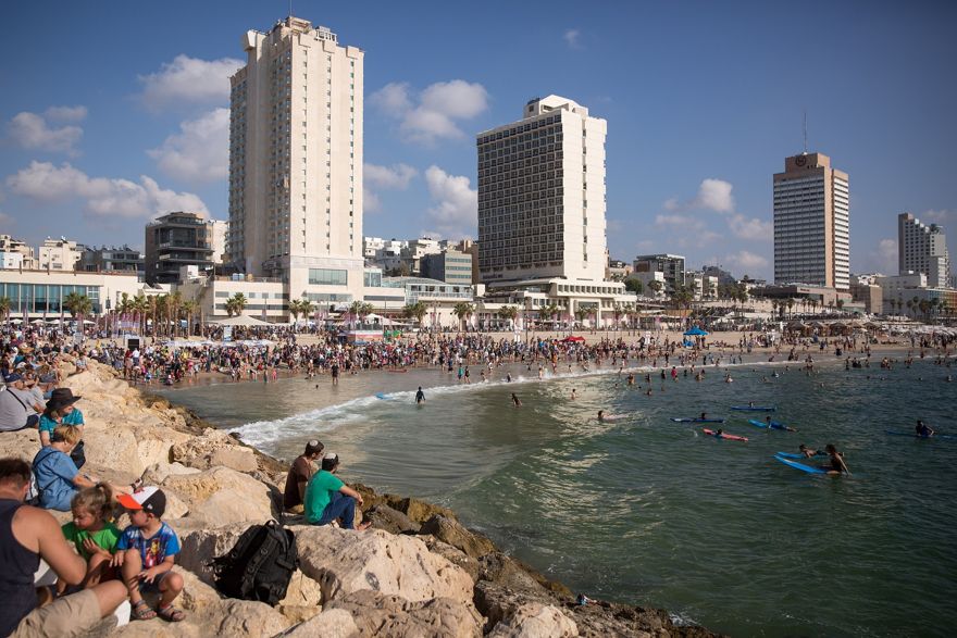 Los israelíes disfrutan del clima cálido en la playa de Tel Aviv, 27 de agosto de 2018. (Miriam Alster / FLASH90)