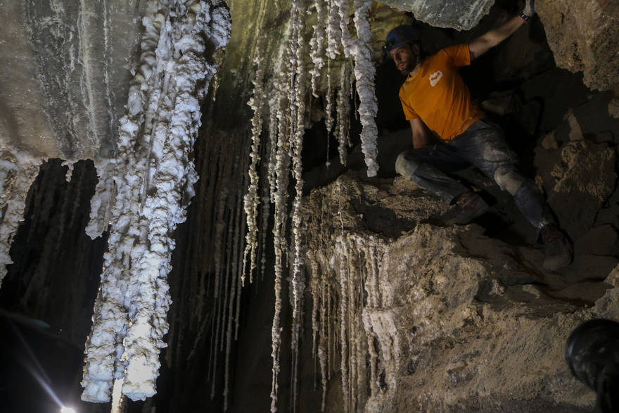 Efi Cohen, parte del Centro de Investigación de Cuevas de la Universidad Hebrea, sobre una roca en una habitación en la Cueva de Malcham llamada 'The Wedding Hall' debido a las impresionantes estalactitas, el 27 de marzo de 2019, cerca del Mar Muerto. (Johanna Chisholm / Tiempos de Israel)