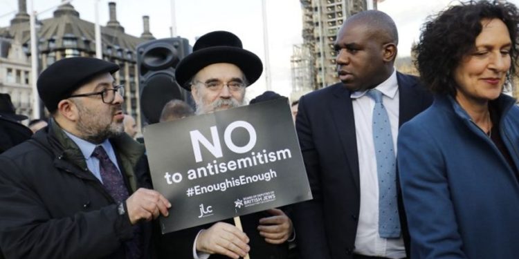 El político del Partido Laborista británico David Lammy (2R) se une a los miembros de la comunidad judía que realizan una protesta contra el líder opositor del Partido Laborista británico Jeremy Corbyn y el antisemitismo en el Partido Laborista, frente a las Cámaras del Parlamento británico en el centro de Londres el 26 de marzo de 2018. (AFP / Tolga Akmen)