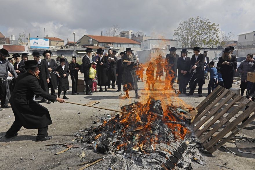 Los hombres judíos ultraortodoxos queman elementos fermentados durante el ritual de Biur Jametz el 19 de abril de 2019 en Jerusalén. (Menahem Kahana / AFP)