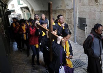 Los peregrinos católicos chinos llevan una cruz de madera a lo largo de la Via Dolorosa en la Ciudad Vieja de Jerusalem durante la procesión del Viernes Santo el 19 de abril de 2019. (Thomas Coex / AFP)