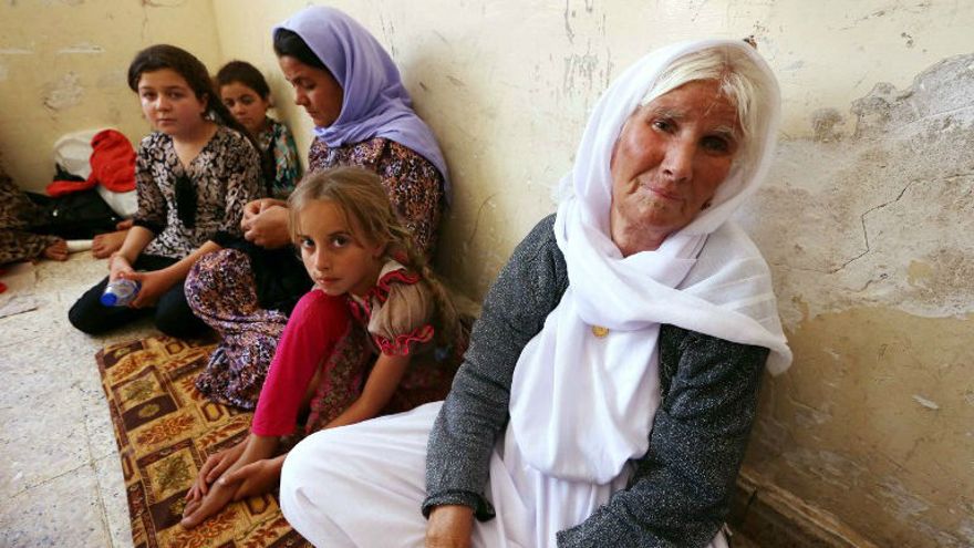 Una familia yazidi iraquí que huyó de la violencia en la ciudad de Sinjar, en el norte de Irak, se sienta en una escuela donde se refugian en la ciudad kurda de Dohuk, en la región autónoma del Kurdistán de Irak, el 5 de agosto de 2014. (Crédito de la foto: AFP / Safin Hamed)