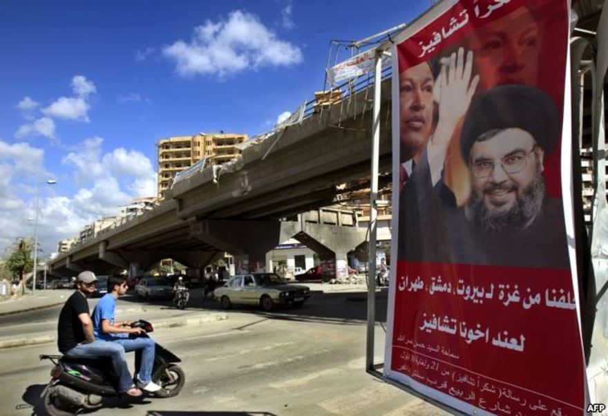 ARCHIVO - Un póster muestra a Hassan Nasrallah, el secretario general de Hezbolá, y al presidente de Venezuela, Hugo Chávez, junto con un eslogan que dice "Gracias Chávez" se ve colgado de un puente destruido en la entrada del suburbio sur de Beirut, el 21 de septiembre. , 2006.