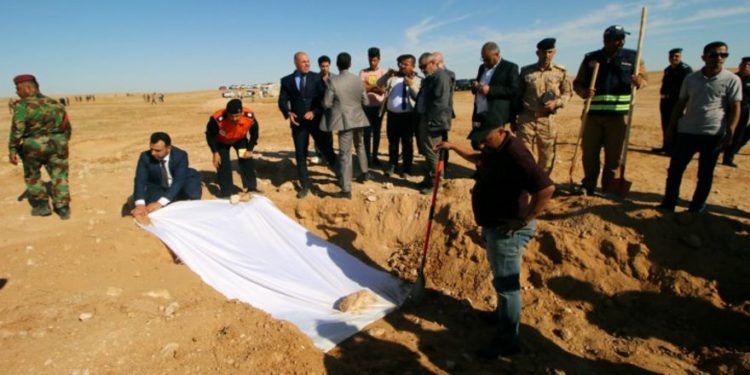 Miembros iraquíes de la Defensa Civil y funcionarios cubren los huesos de una fosa común descubierta de los kurdos al oeste de la ciudad de Samawa, Irak, el 14 de abril de 2019. Foto: REUTERS / Essam al-Sudani.