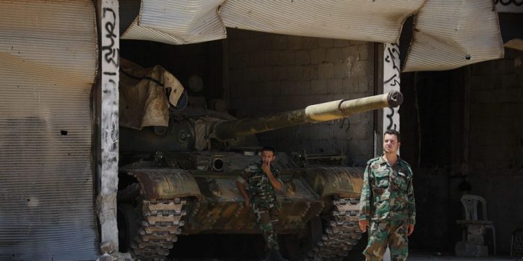 Soldados sirios montan guardia en su puesto militar en la entrada de la ciudad central siria de Rastan, provincia de Homs, Siria, martes 17 de julio de 2018. (AP Photo / Hassan Ammar)