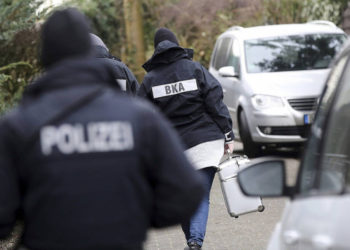 Ilustrativo: El oficial de policía camina entre los autos durante una redada en el pueblo de Meldorf, Alemania, 30 de enero de 2019. (Bodo Marks / dpa via AP)