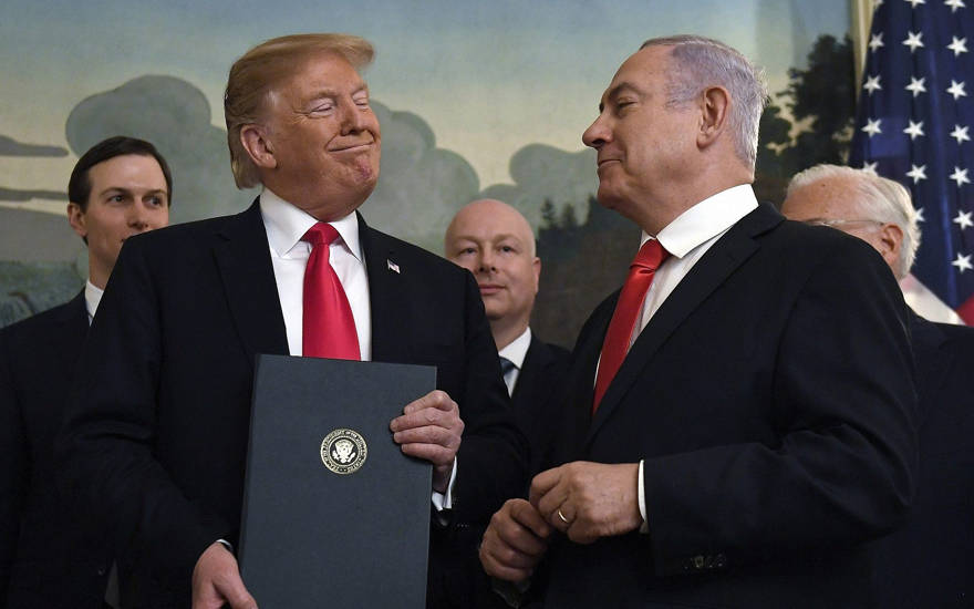 El presidente de los Estados Unidos, Donald Trump, sonríe al primer ministro israelí, Benjamin Netanyahu, a la derecha, después de firmar una proclamación que reconoce formalmente la soberanía de Israel sobre los Altos del Golán, en la sala de recepción diplomática de la Casa Blanca en Washington, el lunes 25 de marzo de 2019 (Foto AP / Susan Walsh)