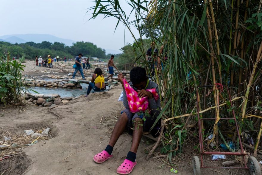 Un migrante venezolano se detiene para descansar al costado de un sendero. Lleva a su hija, de apenas una semana de edad. (Charlie Cordero / Para El Washington Post)