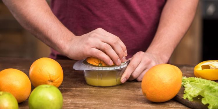Exprimiendo el jugo de naranja. Depositar fotos