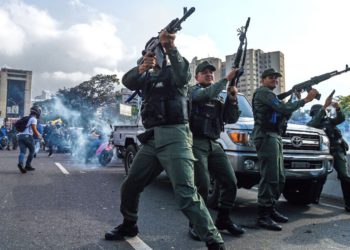 Los miembros de la Guardia Nacional Bolivariana que se unieron al líder opositor venezolano y al autoproclamado presidente Juan Guaido dispararon al aire para repeler a las fuerzas leales al presidente Nicolás Maduro, quien llegó para dispersar una manifestación cerca de la base militar de La Carlota en Caracas el 30 de abril de 2019. (Federico Parra / AFP)