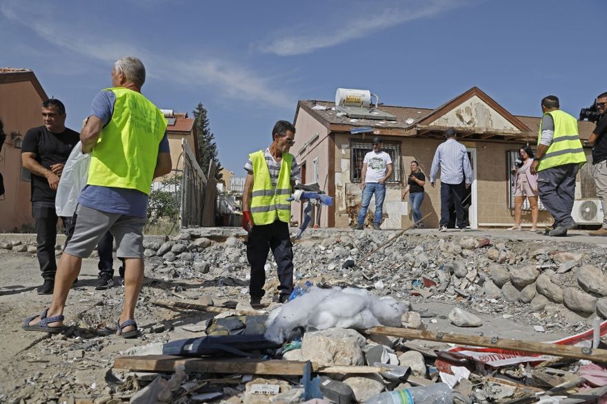 La gente inspecciona los daños en una casa en la ciudad de Beersheba, en el sur de Israel, el 5 de mayo de 2019, luego de haber sido alcanzada por un cohete desde Gaza. (Ahmad GHARABLI / AFP)