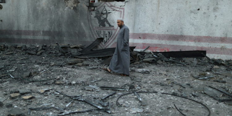 Un hombre palestino camina a través de escombros esparcidos desde un edificio destruido por ataques aéreos israelíes, en la ciudad de Gaza, el 5 de mayo de 2019. (Crédito de la foto: SUHAIB SALEM / REUTERS)