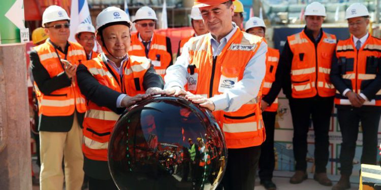 Yisrael Katz (frente), el Ministro de Transporte de Israel y empleados de la Corporación de Ingeniería Ferroviaria de China, participan en un evento que marca el inicio de los trabajos de construcción subterránea del tren ligero, utilizando una Tunnel Boring Machine (TBM), en Tel Aviv, en 2017. (Crédito de la foto: BAZ RATNER / REUTERS)