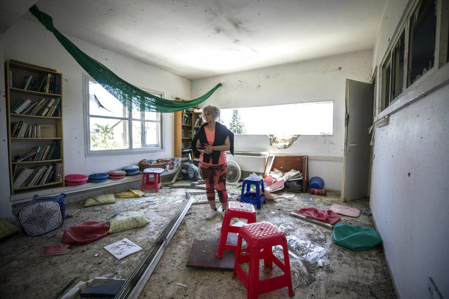 Una mujer observa el daño causado por un cohete lanzado desde Gaza que golpeó una casa en un moshav en Israel, cerca de la frontera con Gaza, el sábado 4 de mayo de 2019. (AP Photo / Tsafrir Abayov)