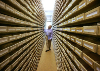 Gary Mokotoff, un genealogista judío de Nueva Jersey, echa un vistazo a los registros de nombres en el Servicio de Rastreo Internacional en Bad Arolsen, Alemania central. | Archivos: AP / Michael Probst