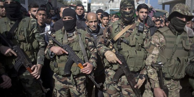 Hombres armados enmascarados participan en el funeral de Mahmoud al-Nabahin, miembro del ala militar de Hamas, en el campamento de refugiados de Buriej, en el centro de la Franja de Gaza, el 23 de enero de 2019. (Foto AP / Khalil Hamra)