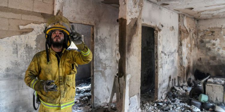 Los bomberos observan los daños causados ​​por un incendio en Kibbutz Harel, el 24 de mayo de 2019. (Noam Revkin Fenton / Flash90)