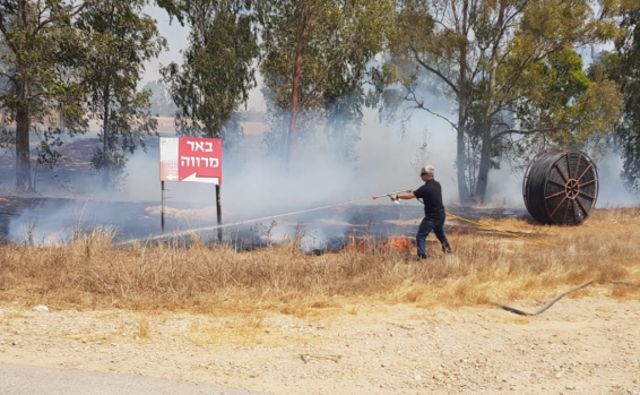 Un bombero lucha contra uno de los incendios en el Negev occidental por globos incendiarios de la Franja de Gaza | Fotografía: Moshe Bruchi / JNF