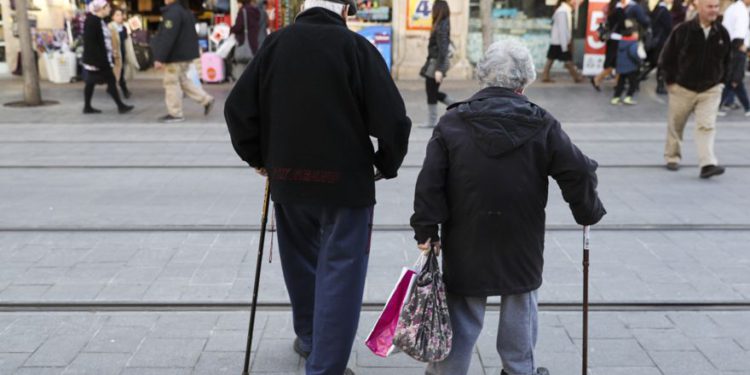 Una pareja de ancianos camina en la calle Jaffa en el centro de Jerusalén el 20 de febrero de 2017. (Nati Shohat / Flash90)