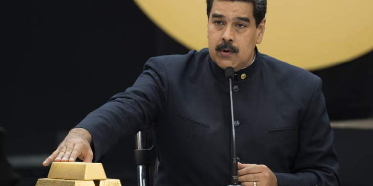 El presidente de Venezuela, Nicolás Maduro, toca una barra de oro mientras habla en una reunión con los ministros responsables del sector económico en el Palacio de Miraflores en Caracas, Venezuela, 22 de marzo de 2018. Crédito: REUTERS / Marco Bello / Foto de archivo