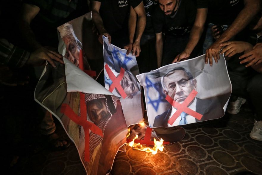 Los palestinos queman carteles del presidente de Estados Unidos, Donald Trump, el primer ministro Benjamin Netanyahu y el rey Hamad al-Khalifa de Bahrein, en la ciudad de Rafah, al sur de la Franja de Gaza, el 25 de junio de 2019, durante una protesta contra la conferencia de Paz a la Prosperidad dirigida por Estados Unidos en Bahrein. (Dijo KHATIB / AFP)