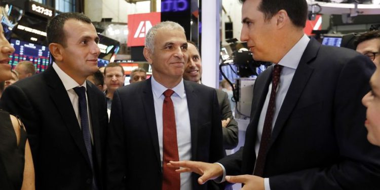 El director general del Ministerio de Finanzas, Shai Babad (izquierda) y el ministro de Finanzas, Moshe Kahlon (centro), escuchan al vicepresidente de NYSE John Tuttle en la Bolsa de Nueva York el lunes | Foto: AP / Richard Drew