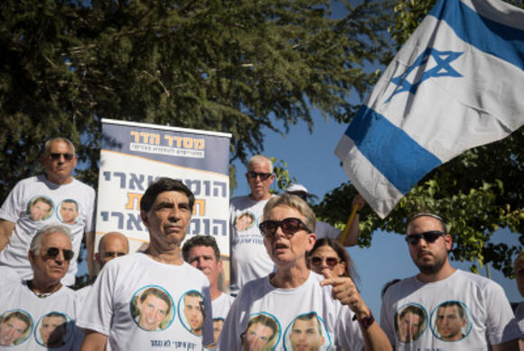Los padres en duelo de Hadar Goldin y otros miembros de la familia y simpatizantes se reúnen fuera de la ceremonia conmemorativa estatal para la Operación Borde Protector en Mount Herzl el 23 de julio de 2019. (Noam Revkin Fenton / Flash90)