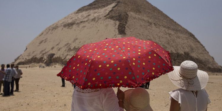 Un miembro de una delegación internacional dibuja el sitio de la pirámide doblada durante un evento que abre la pirámide y sus satélites para los visitantes en Dashur, Egipto, sábado 13 de julio de 2019 (Foto AP / Maya Alleruzzo)