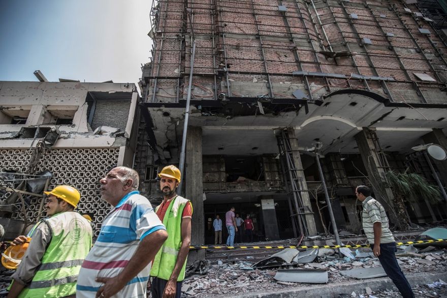 Los egipcios caminan afuera del Instituto Nacional del Cáncer en la capital, El Cairo, el 5 de agosto de 2019, donde se produjo un accidente y un bombardeo justo antes de la medianoche del día anterior. (Khaled DESOUKI / AFP)