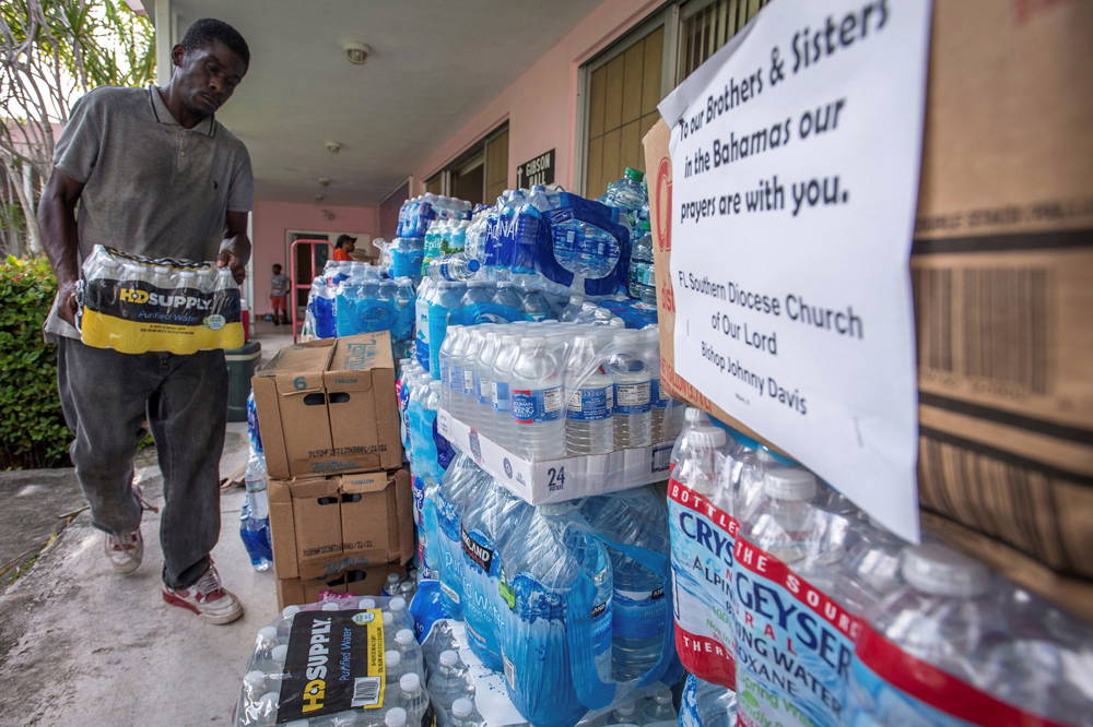 Un voluntario junta agua para los damnificados (EFE)
