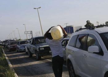 Un hombre lleva un contenedor de gasolina mientras otros autos esperan en la fila para comprar gasolina en una estación de servicio de Pemex en San José del Cabo, después del huracán Odile en Baja California. (crédito de la foto: REUTERS)