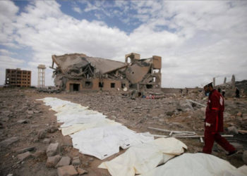 Un médico de la Media Luna Roja camina junto a bolsas que contienen los cuerpos de las víctimas de los ataques aéreos liderados por Arabia Saudita en un centro de detención hutí en Dhamar, Yemen, el domingo | Foto: Reuters / Mohamed al-Sayaghi