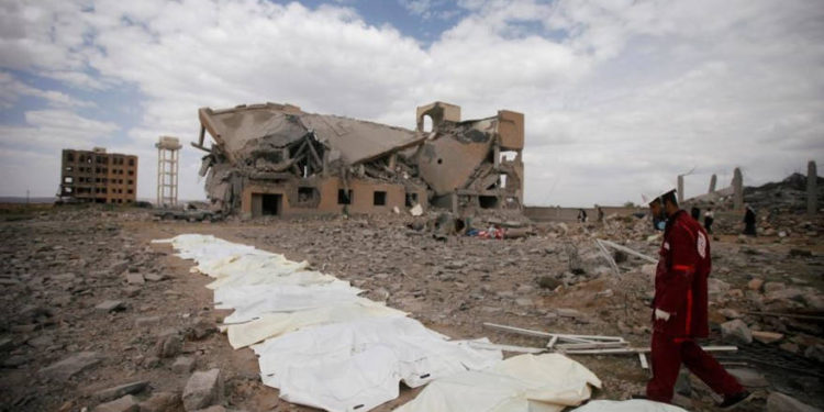 Un médico de la Media Luna Roja camina junto a bolsas que contienen los cuerpos de las víctimas de los ataques aéreos liderados por Arabia Saudita en un centro de detención hutí en Dhamar, Yemen, el domingo | Foto: Reuters / Mohamed al-Sayaghi