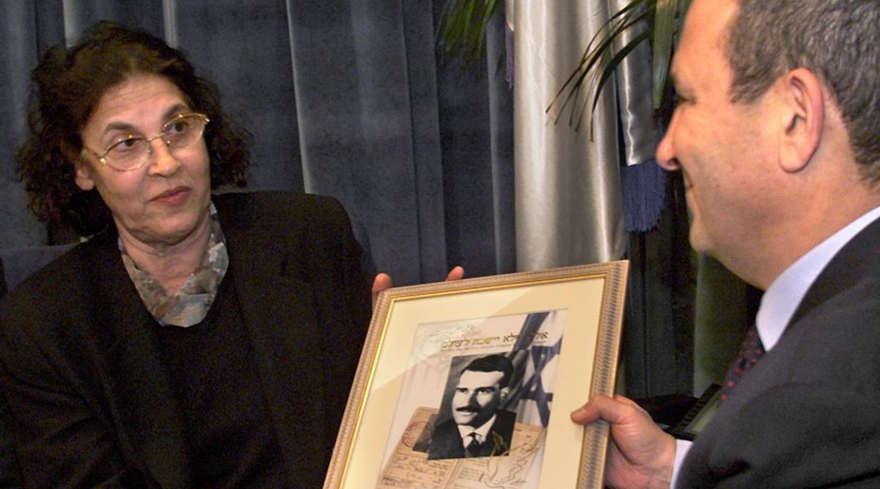 El primer ministro israelí, Ehud Barak, recibe una foto de un nuevo sello postal que conmemora a Eli Cohen, de su viuda Nadia Cohen, el 25 de enero de 2000. (Menahem Kahana / AFP / Getty Images)